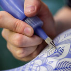 Rhian Malin decorating a mandala bottle in her workshop 2019